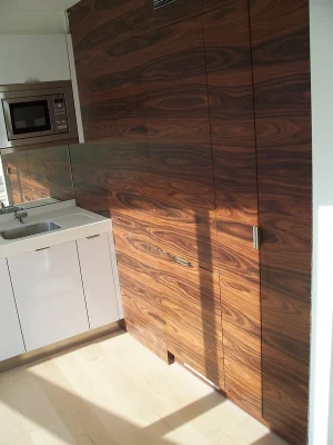 brown fitted wardrobe in kitchen with sink and microwave