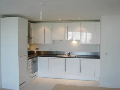 white kitchen with custom furniture, fridge and sink