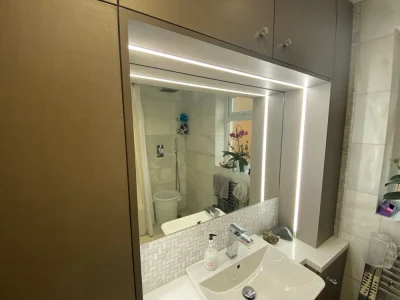 bathroom with a mirror at the sink and a flower in the reflection